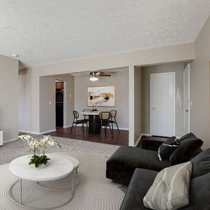 A living room with a television, couches, and a coffee table. Omaha, NE Evergreen Terrace Apartments