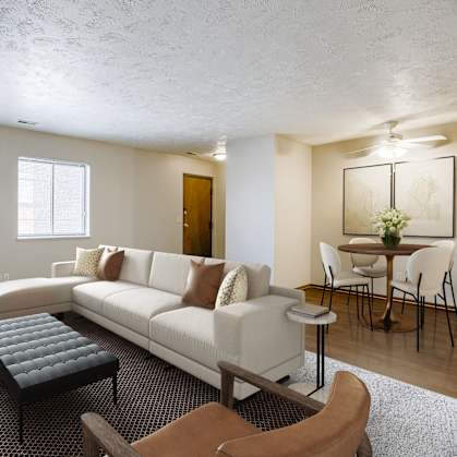 A living room with a white couch and a black coffee table. Omaha, NE Stony Brook Apartments