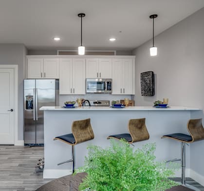 a kitchen and living room with white cabinets and a counter