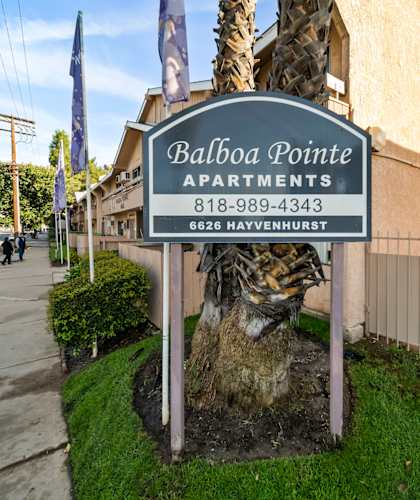 A sign for Balboa Pointe Apartments is displayed in front of a building.