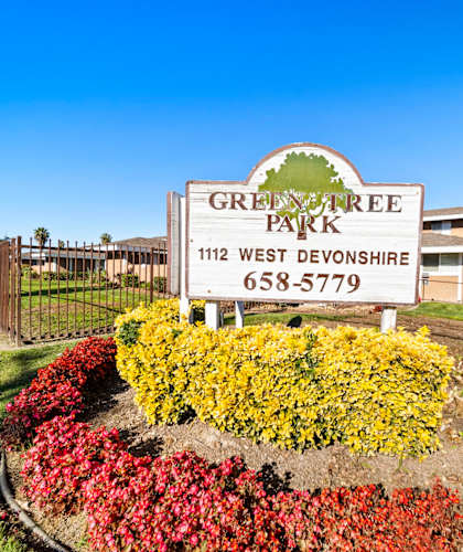 A sign for Green Tree Park in West Devonshire with a phone number on it.