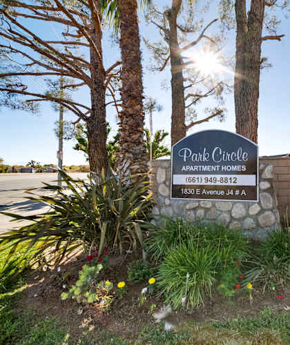 A sign for Park Circle Apartment Homes stands in front of a building.