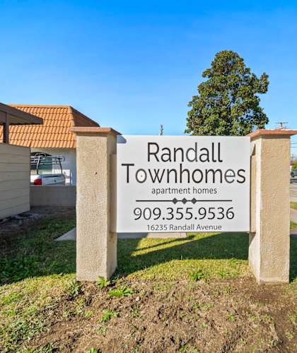A sign for Randall Townhomes stands in front of a building.