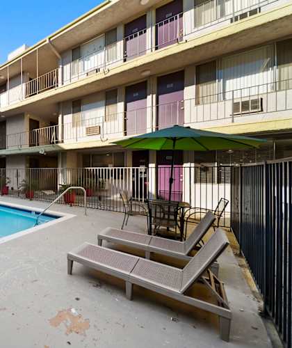 A pool in a courtyard surrounded by apartment buildings.