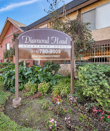 A sign for Diamond Head Apartment Homes stands in front of a building.