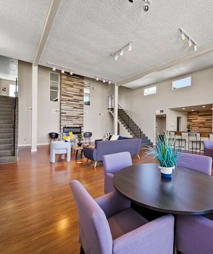 A large room with a round table and purple chairs.