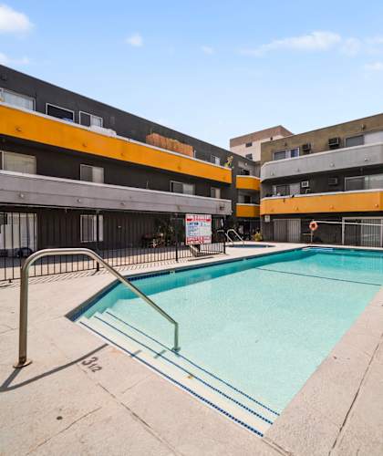 A small pool in a courtyard surrounded by buildings.