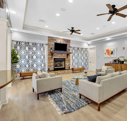 A living room with a fireplace and a ceiling fan.