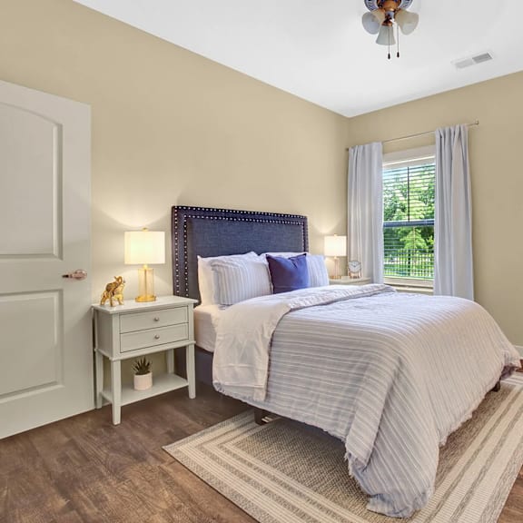 A bedroom with a large bed and a ceiling fan.