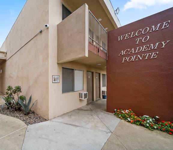 The front of the Academy Pointe building is shown with a welcome sign.
