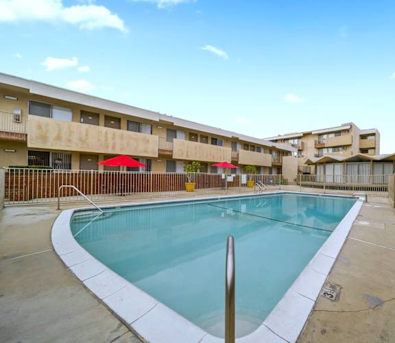 A swimming pool in a courtyard surrounded by buildings.