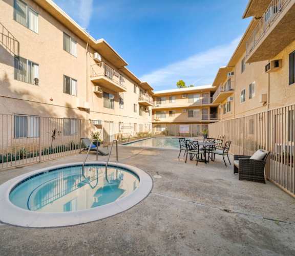 A small pool in a courtyard surrounded by buildings.