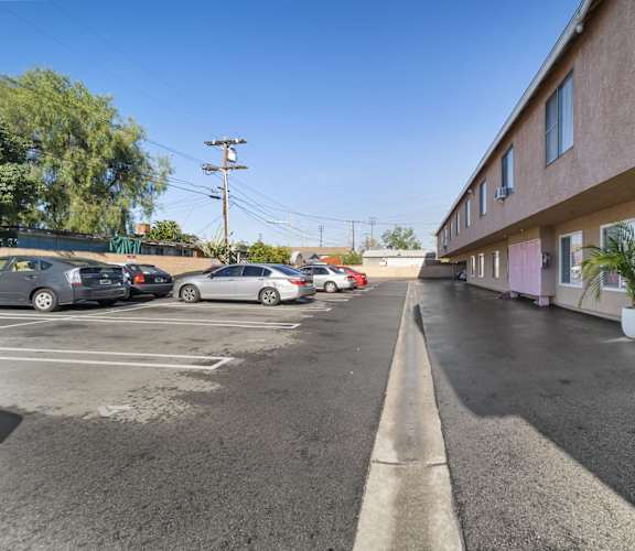 A parking lot with cars parked and a building on the right side.