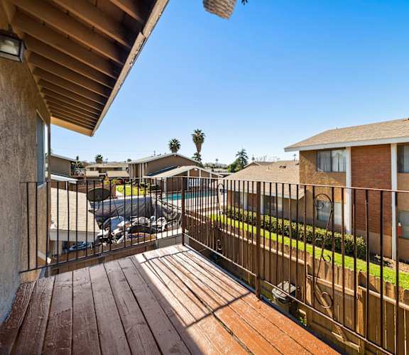 A balcony with a wooden floor and a metal railing.