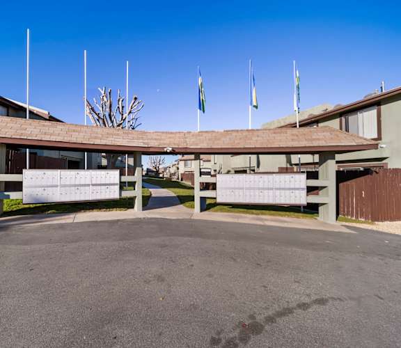 A building with a covered walkway and flags on top.