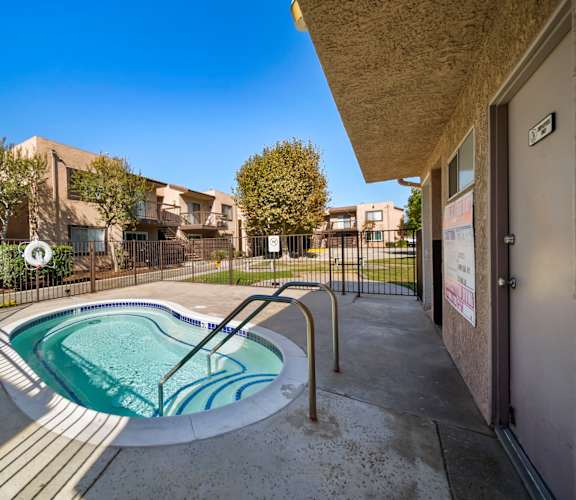 A small pool in a courtyard surrounded by buildings.