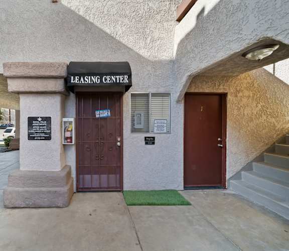 The leasing center has a brown door and a green mat in front of it.