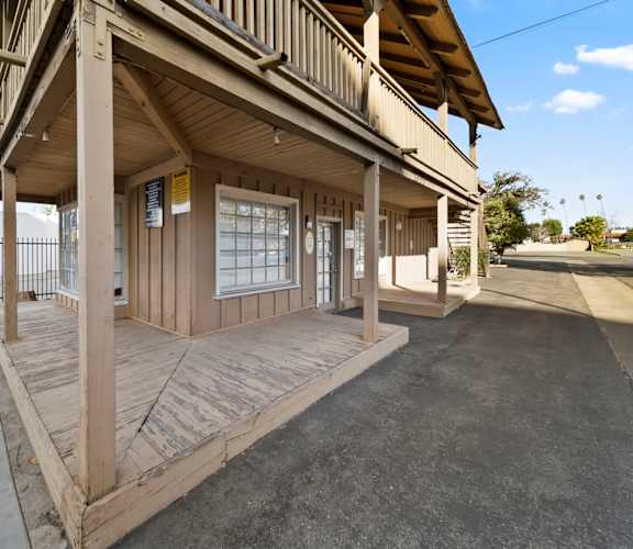 A wooden building with a porch and a covered walkway.