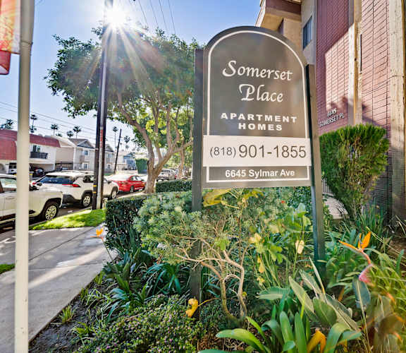 A sign for Somerset Place Apartment Homes is in front of a building.