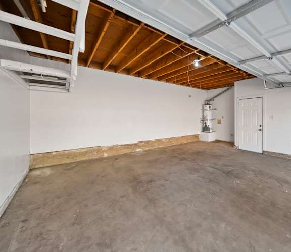 A spacious room with a concrete floor and a white door.