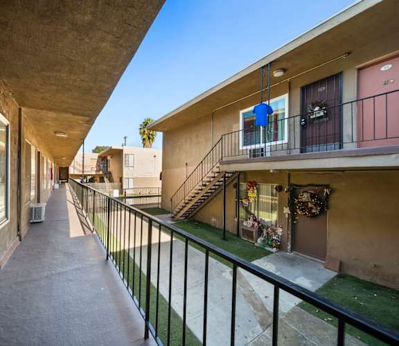 A long concrete balcony with a black railing.