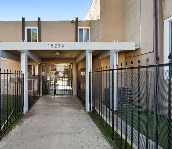 A long concrete walkway leads to a building with the number 15234 on it.