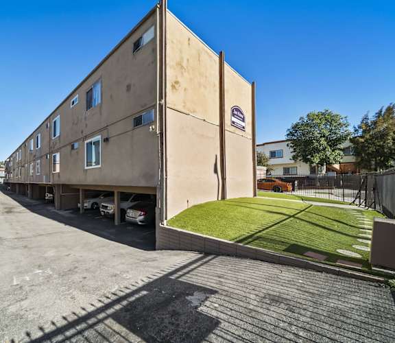 A long building with a car parked in front of it.