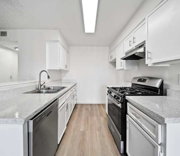 A kitchen with white cabinets and a black stove top oven.