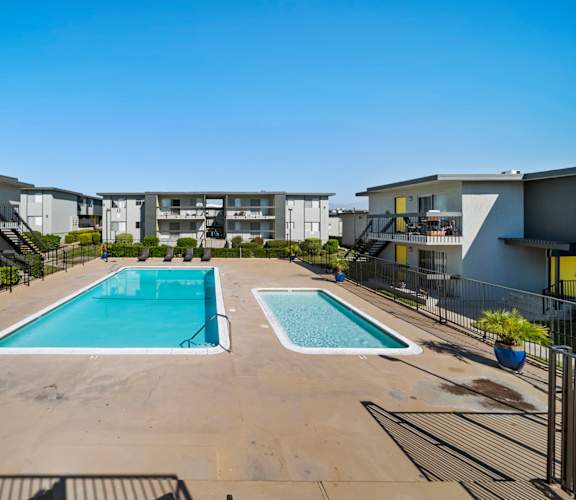 A swimming pool in a courtyard surrounded by buildings.