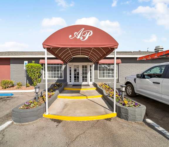 A red and white sign with the letters "DGP" is on a red awning over a set of double doors.