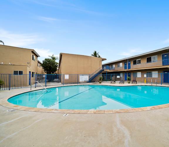 A large outdoor swimming pool surrounded by a fence.