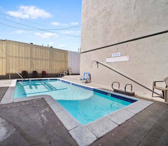 A small pool with a diving board and a sign that says "SWIMMING POOL".