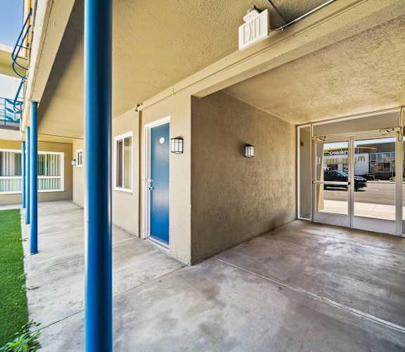 A blue door is on the left side of a building.