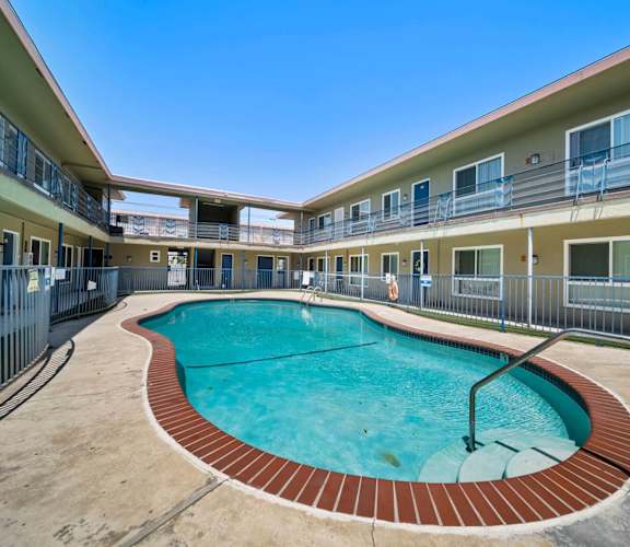 A swimming pool in a courtyard surrounded by apartment buildings.
