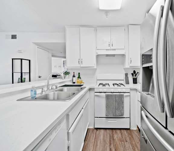A modern kitchen with white appliances and cabinets.