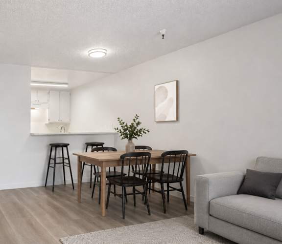 A dining room with a table and chairs.