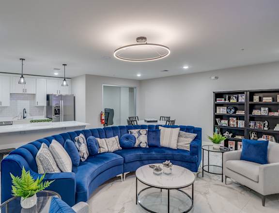 A modern living room with a blue sofa and a glass coffee table.