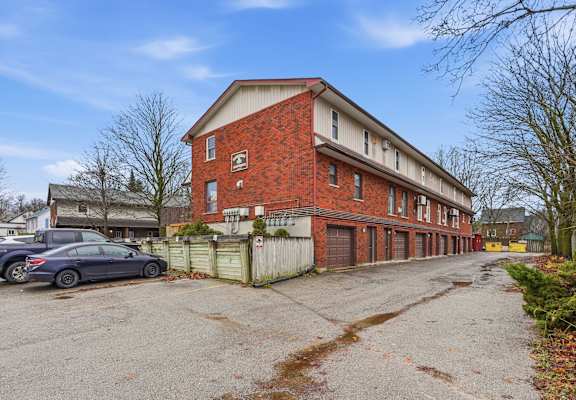 A red brick building with a car parked in front.