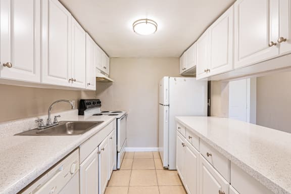  a kitchen with white cabinets and a white door at Del Rio Apartment