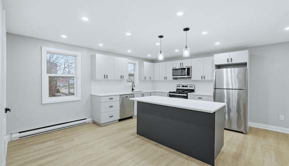 A kitchen with white cabinets and stainless steel appliances.