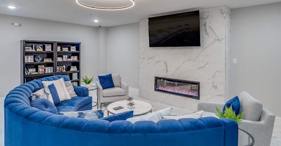 a living room with a blue couch and a fireplace