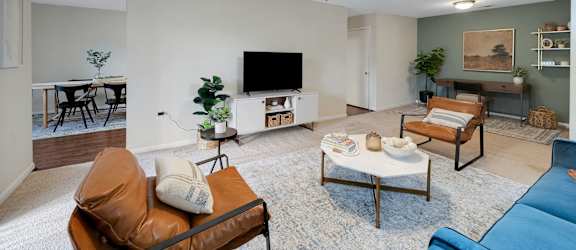 a living room with a ceiling fan and a tv