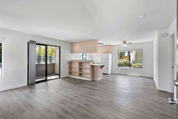 a living room with a kitchen and a sliding glass door