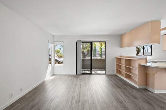 a living room with wooden floors and a door to a patio