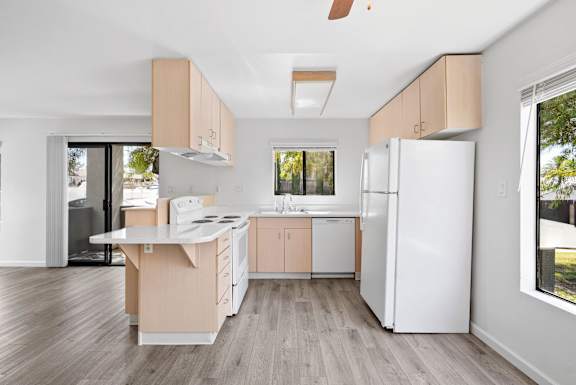 a kitchen with white appliances and wooden cabinets