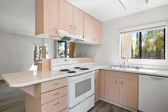 a kitchen with white appliances and wooden cabinets