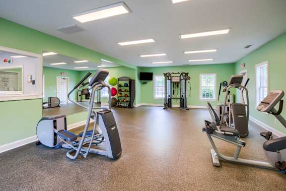 an exercise room with treadmills and other fitness equipment
