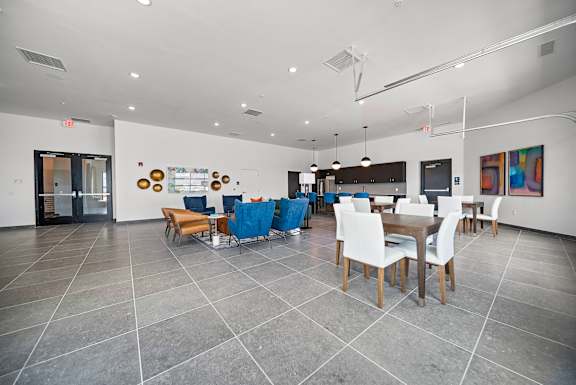 A dining room with a table surrounded by chairs.