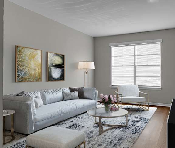 A living room with a grey couch, a white chair, a coffee table, and a flat screen TV.