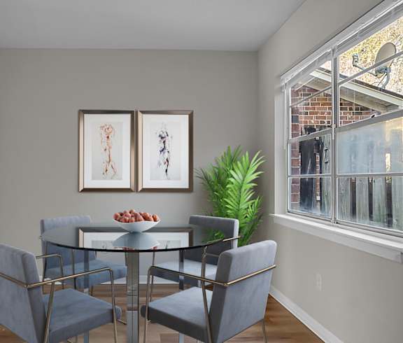 A dining room with a glass table and grey chairs.